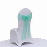 A white fabric-covered chair with a sheer tiffany organza bow tied around the backrest, shown on a plain white background.